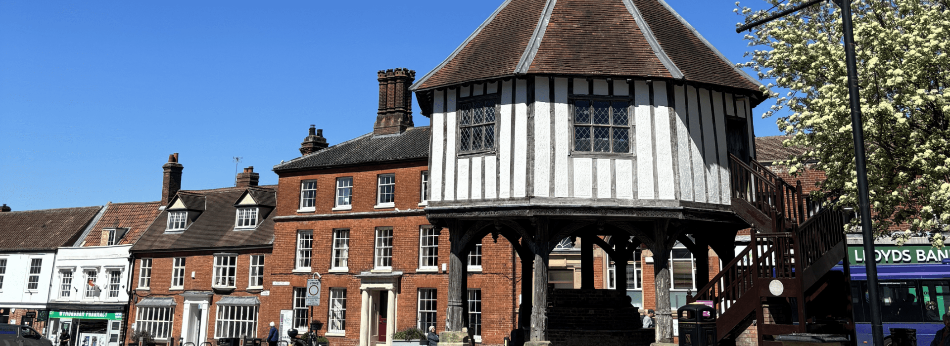 Wymondham Market Cross and historic Market Place surrounded by independent businesses and heritage buildings
