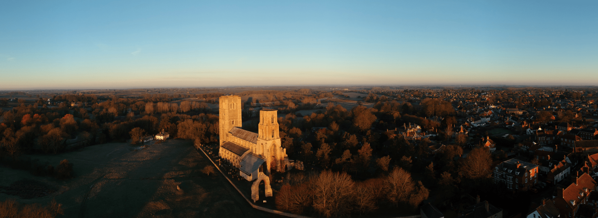 Aerial view of Wymondham Abbey at sunrise overlooking the historic market town and surrounding countryside